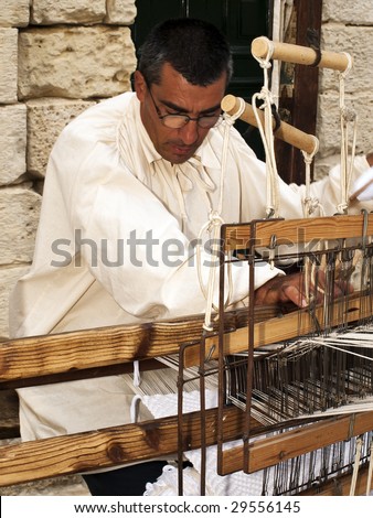 MDINA, MALTA - APR 19 : A weaver uses medieval tools to produce cloth April 19, 2009 in Mdina, Malta.