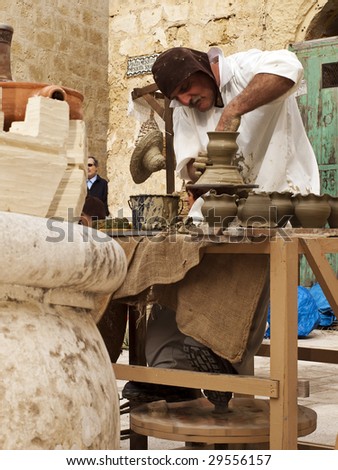 MDINA, MALTA - APR 19 : A potter uses medieval tools to produce clay jars April 19, 2009 in Mdina, Malta.