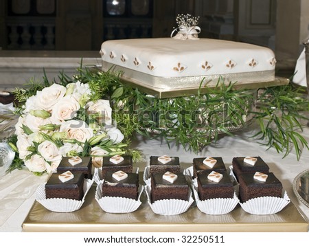 Wedding chocolate cakes and main wedding cake with bridal bouquet