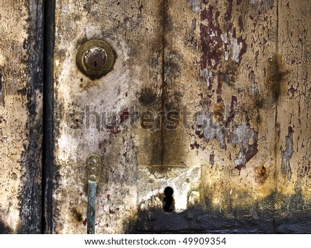 Detail image of an old wooden seaside door with multiple layers of flaking paintwork