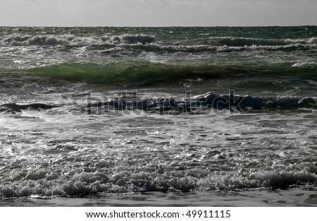Emerald waves breaking onto the shore in Golden Bay in Malta. Was trying to capture a big fish I saw amidst the waves and caught it silhoutted in a wave.