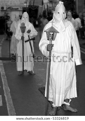 MOSTA, MALTA - APR 02: Hooded men in white habits dragging chains during the Mosta Good Friday procession in Malta April 02, 2010
