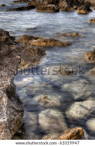 Shallow ocean water and a multitude of rocks and stones along the coast