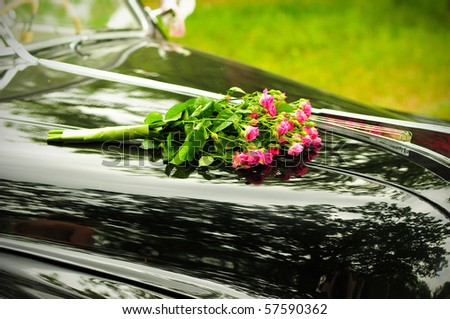 stock photo Pink wedding bouquet on cowl of black car