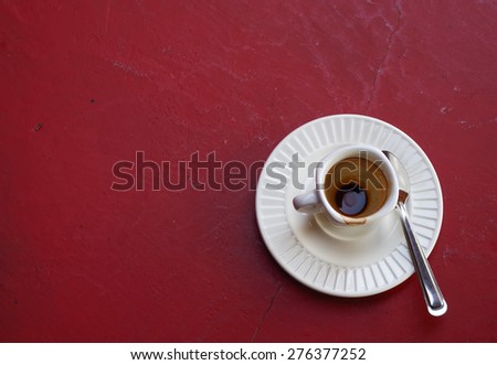 empty glass of hot coffee on the red table