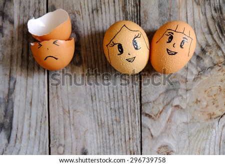drawing cartoon on three eggs lay on a wooden table, focus on egg