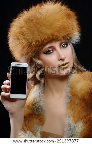 beautiful woman with make-up in fur fox holding a phone