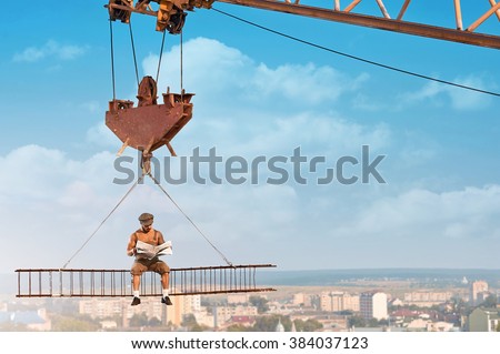 Ready for the news. Fearless old fashioned builder man reading a newspaper sitting on a crossbar hanging on a crane above the city