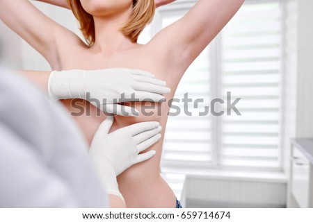 Cropped shot of a woman standing topless getting her breast examined during medical appointment at the hospital copyspace cancer awareness prevention examination checkup medicine health.