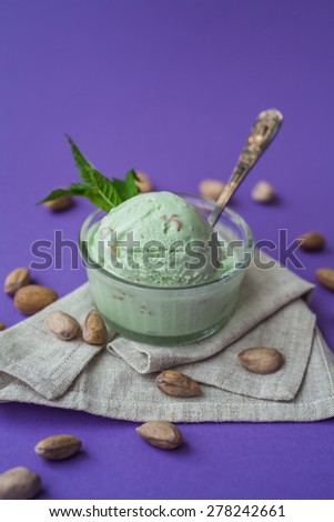 pistachio ice cream with mint leaves on a purple background