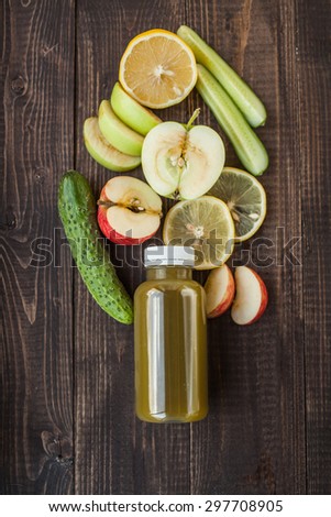 Detox juice with apple, lemone and cucumber on wooden desk