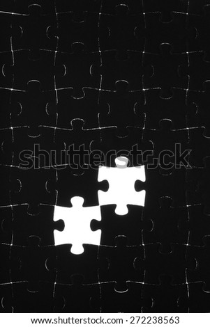 Black puzzle laid out on a white background