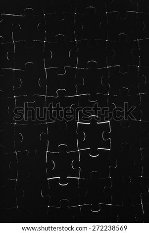 Black puzzle laid out on a white background