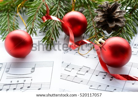 Christmas decorations and fir branch lying on notes sheet