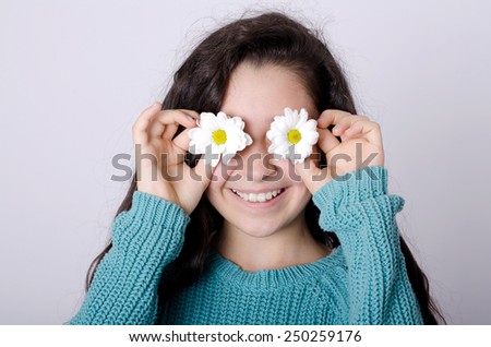 Smiling Young Girl Covering her eyes with Flowers