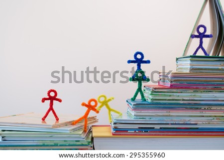 A line of rainbow people stumbling, but making it up the ladder of success through reading and education. A lovely photo for international or multicultural ideas and concepts for adults and children.