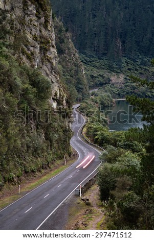 A winding road through a gorge in New Zealand. Wonderful photo for depicting any ideas or concepts about cars, adventure, speed, movement, or the roads we take in life, or many other themes.