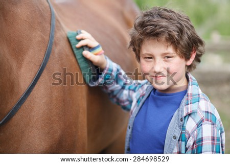 little boy clean his horse