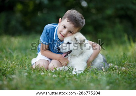 Malamute puppy and boy, best friends; Outdoor portrait