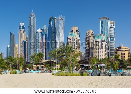 DUBAI, UNITED ARAB EMIRATES - MARCH 10, 2016: People relaxing on Jumeirah beach in Dubai Marina luxury hotels,United Arab Emirates
