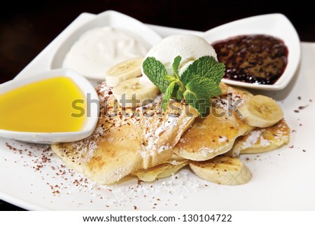 American-style pancakes. Banana and ice cream, with chocolate, jam, sour cream and honey