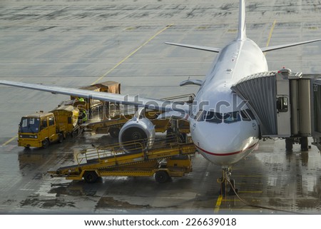 Munich, Germany - October 16: Ground crew refueling and working below a passenger airplane in Munich on October 16, 2014.Munich, Germany
