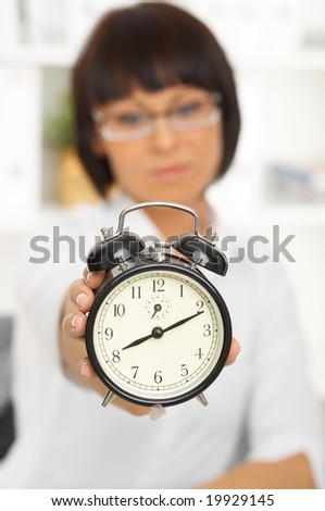 Beautiful business woman with clock in office