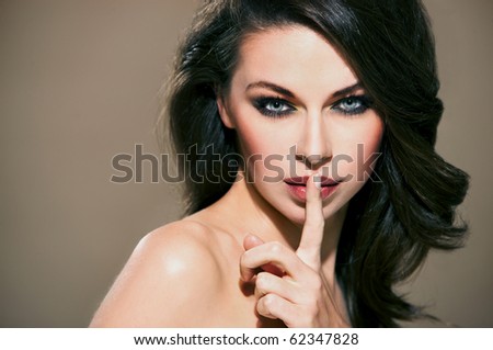 Portrait of beautiful woman with silence sign isolated on beige with copyspace