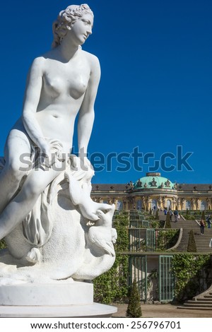 Marble statue with Sans Souci palace in the background in Potsdam, Germany
