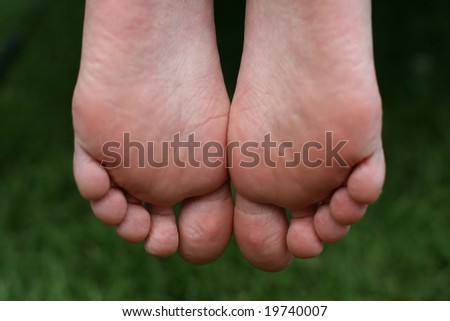 Young girl\'s feet on a  green background