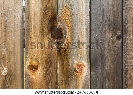 brown wood fence with mirrored knot hole
