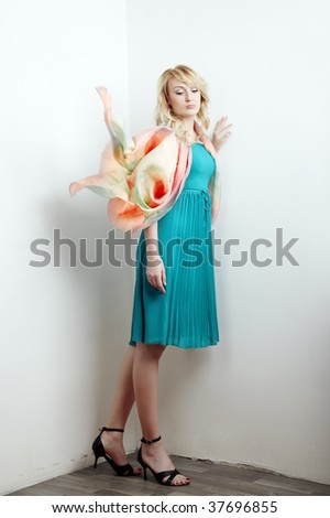Sad lady standing in the corner in stylish dress and scarf
