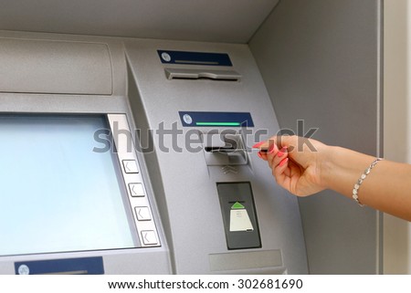 woman hand inserting credit card to ATM