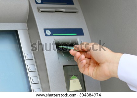 man hand inserting credit card to ATM