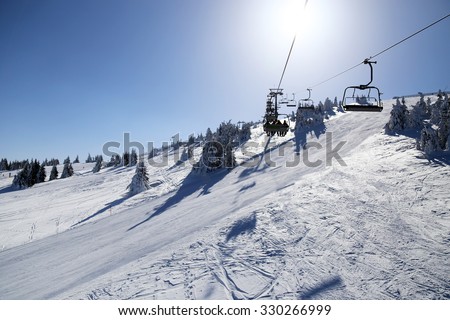 ski lift and ski run in sunny winter day