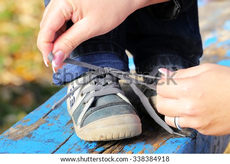 mother tying little shoes outdoor