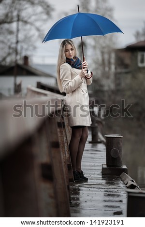 Young girl on a bridge on a cloudy rainy day