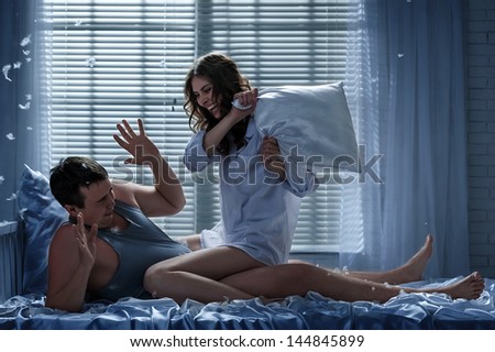 Young couple in love on the bed in the moonlit night