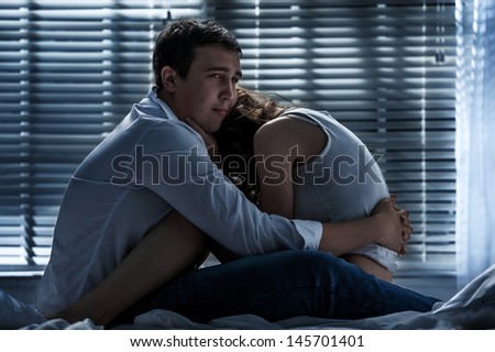 Young couple in love on the bed in the moonlit night