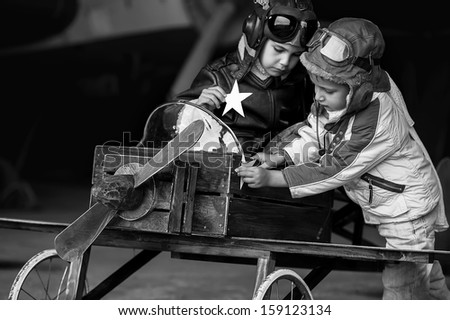 Young aviators in homemade aircraft in a large hangar Young aviators in homemade aircraft in a large hangar