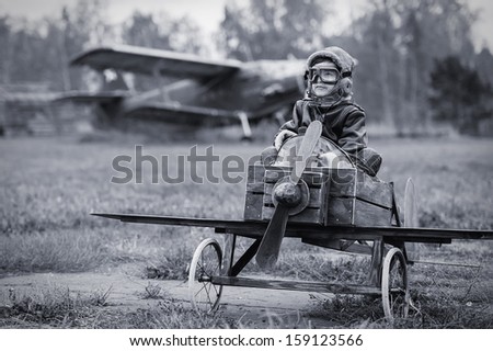 Young boy-pilot in the plane at the airport handmade autumn Young boy-pilot in the plane at the airport handmade autumn