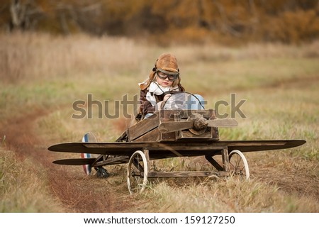 Young Female Pilot In A Homemade Plane In A Field On A Sunny Autumn Day
