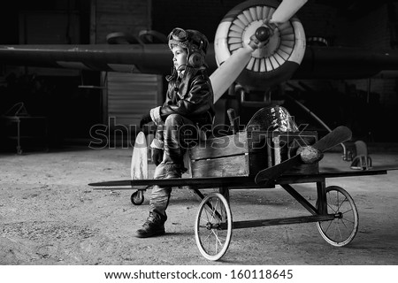 Young Aviator in a homemade aircraft in a hangar with these planes