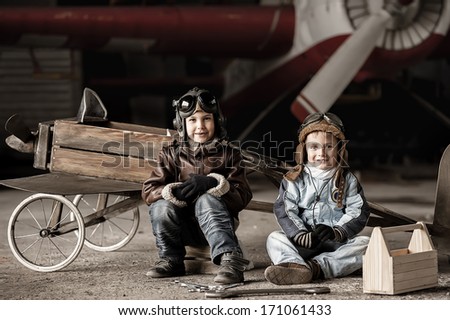 Young Aviators in a homemade aircraft in a hangar with these planes