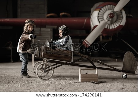 Young Aviators in a homemade aircraft in a hangar with these planes