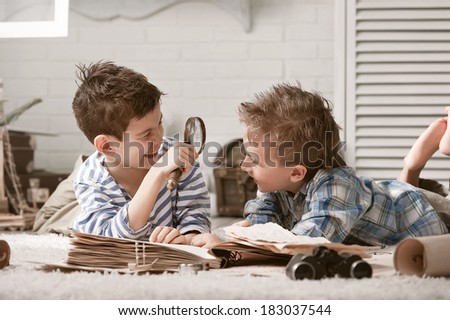 Two boys travelers studying maps and old books in his room