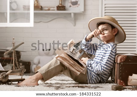 Boy in the image traveler studying his book of travel and adventure in her room