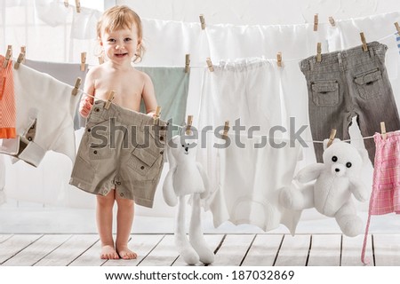 Little girl hangs laundry or toys in the laundry Little girl hangs laundry or toys in the laundry