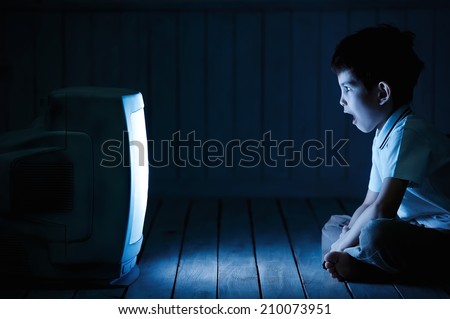 Little boy watching TV one night on the floor