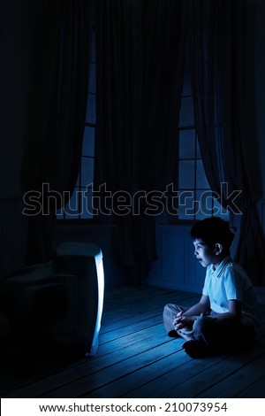 Little boy watching TV one night on the floor
